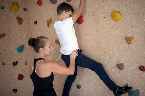 Hilfestellung beim Therapeutischen Klettern an einer Kletterwand